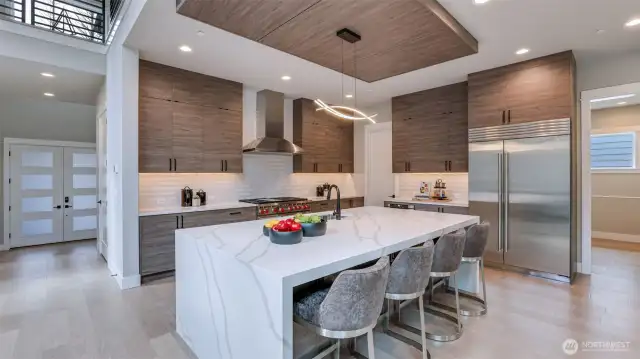 Enviable gourmet kitchen boasts 48" Subzero Refrigerator, Wolf Double-Oven, 6 Burners & Griddle Range, 48" Zephyr Pro Wall Hood, Microwave Drawer, and anchored by an oversized waterfall island.