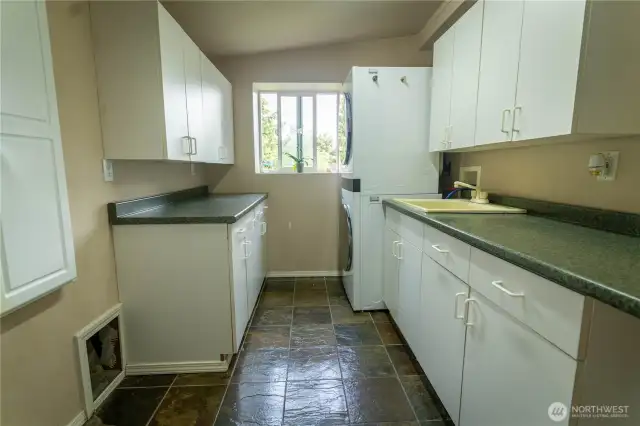 Laundry room with deep sink and multiple storage cabinets on the main floor.