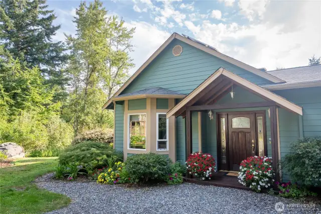 Beautiful covered entry porch with elegant wood doors and side windows.