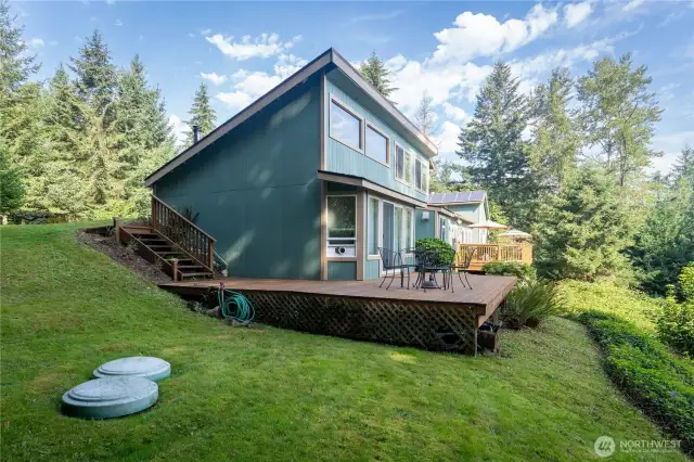 Side view from North side with a separate ADU deck.  Septic tank lids in lower left corner.