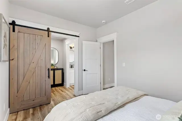 Walkthrough closet off Primary with Knotty Alder barn door and Matte Black hardware.