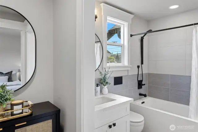 Walkthrough closet view into Primary Bathroom with European design tub and matte black plumbing trim.