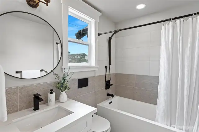 Primary bathroom also featuring a concealed tank wall hung toilet & undermount sink.