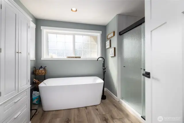 There is a newer freestanding tub and shower in the primary bathroom