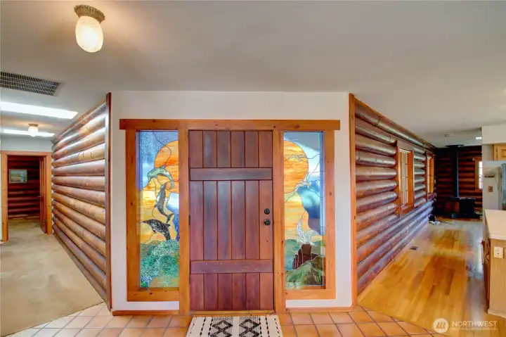 Facing front door from the inside looking down two hallways. Hallway on left leads to bedrooms and right leads through kitchen to cozy den.