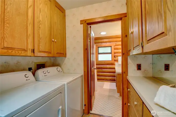 Laundry room with abundant cabinet and drawer storage, conveniently connecting to the primary bath.
