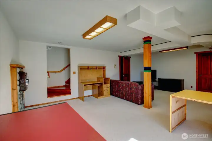 Basement view looking at the stairs to main level. Two large walk-in storage closets in the basement provide built-in shelving and worktops for versatile use.