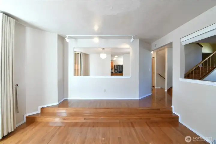 bright living room open to raised dining room and hallway access