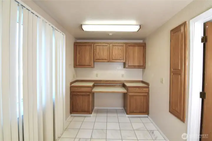 spacious utility room with tile flooring, build-in cabinets, and countertop workspace