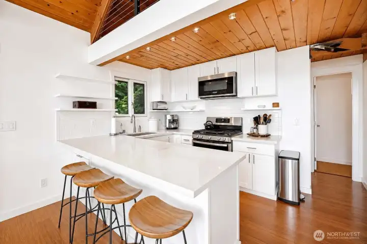 Beautiful kitchen with quartz countertops and bar stool seating, perfect for casual dining and entertaining.