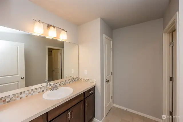 The main bathroom offers a separate showering and toilet area, along with a linen closet and plenty of vanity space.