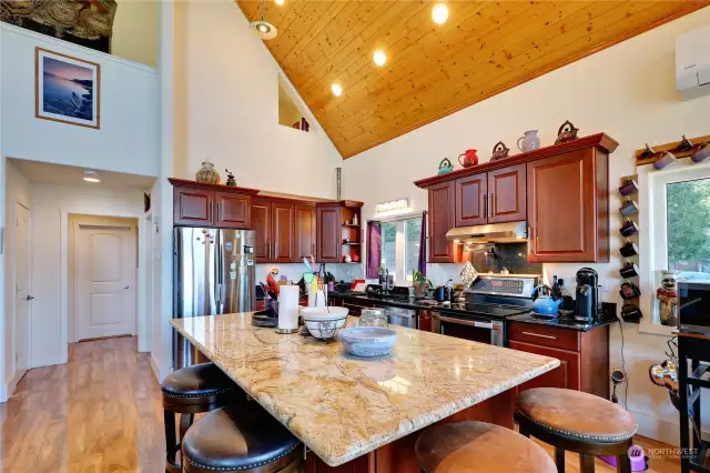 The kitchen cabinets are solid wood.  The granite island is huge and seats four for casual dining. The black quartz counters are nearly new.
