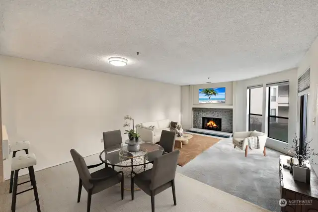 Living room with fireplace, dining, & open kitchen with eating area.