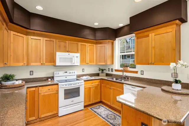 Spacious kitchen with solid wood cabinets and granite counters.