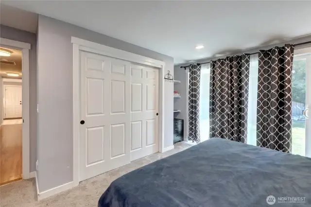 Primary Bedroom w/ en suite, built-in shelves and private access to back patio.