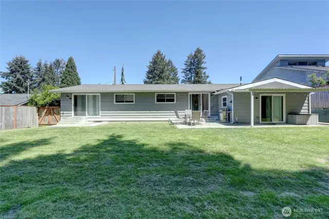 Level backyard with gates on both sides of the home.