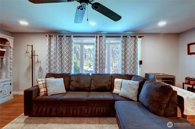 Living room with tons of light and a ceiling fan to keep you cool on warm days.
