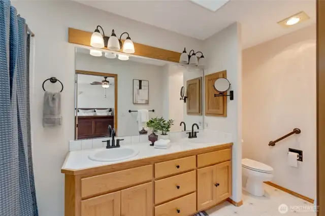 The attached en-suite bathroom is both functional and elegant, featuring dual sinks, a tub/shower combo, and tasteful finishes throughout.