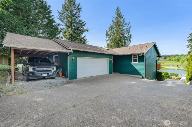 The attached two-car garage, plus an additional covered carport, ensures ample parking and storage space for vehicles, toys, and tools.