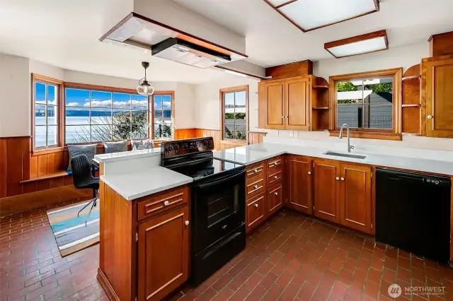 Prepare meals with a view in this waterside kitchen where classic wood cabinetry, wraparound counters, and smart layout meet the timeless beauty of Puget Sound. Whether you're whipping up breakfast with Olympic peaks in sight or gathering guests around the peninsula, this space serves as both culinary workshop and coastal lookout.