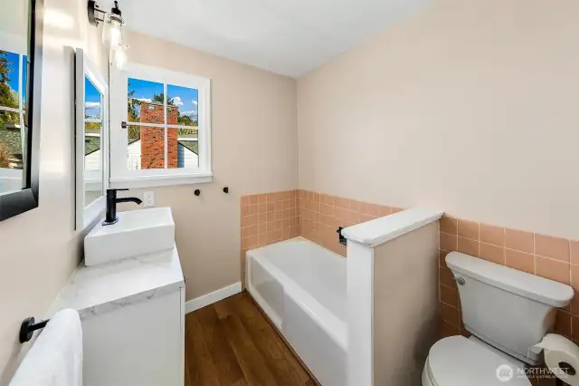 With its vintage tile wainscoting, updated vanity, and peek-a-boo water views, this second bath blends retro character with modern touches. Natural light pours in, making this an inviting spot for a morning soak or a post-beach refresh—part of the home’s layered charm in this storied corner of Browns Point.