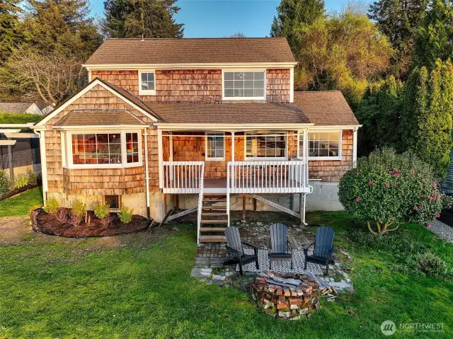 Set on an expansive 11,657 sq ft lot, this west-facing Cape Cod offers room to breathe and space to grow. The level lawn stretches out from the elevated deck to a cozy firepit terrace—perfect for entertaining, gardening, or future expansion. Sheltered by mature trees and open to panoramic Sound views, the property delivers rare utility and flexibility in a setting that feels both grand and grounded.