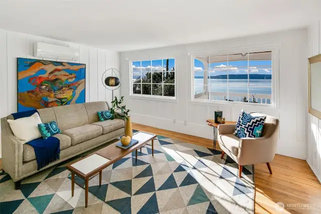 Framed by generous picture windows, the Salish Sea stretches wide from this sun-drenched living room. Hardwood floors, crisp white walls, and vintage detailing create a canvas of calm, while views of Vashon Island and the Olympic Mountains invite you to linger, dream, and connect with the rhythms of coastal life in Browns Point.
