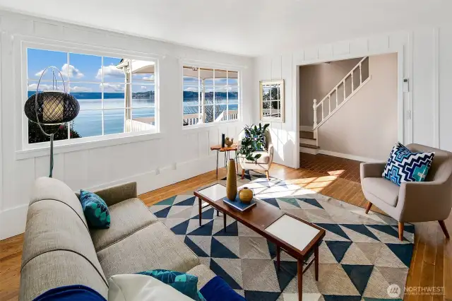 Every glance out the window brings a new masterpiece—drifting clouds, ferry wakes, and the glint of Olympic peaks. This serene living space welcomes both quiet reflection and lively conversation, with hardwood floors underfoot and the stairway beckoning you to explore further. A coastal sanctuary where indoor comfort meets the drama of Puget Sound.