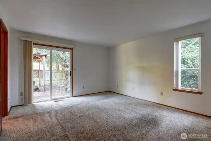 Spacious primary bedroom with a sliding glass door providing direct access to the backyard.