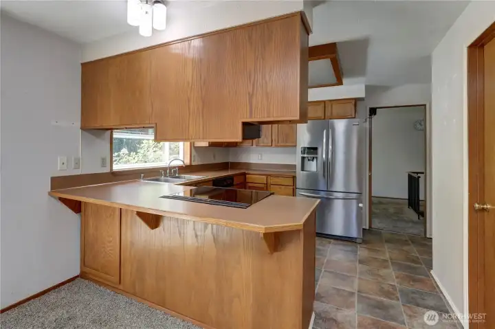 Lovely kitchen featuring generous counter space, ample storage, and an open breakfast bar perfect for everyday living.