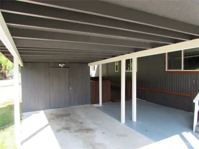 STORAGE SHED IN PARKING AREA, LARGE COVERED AREA IN FRONT OF HOME, FACING SOUTH.