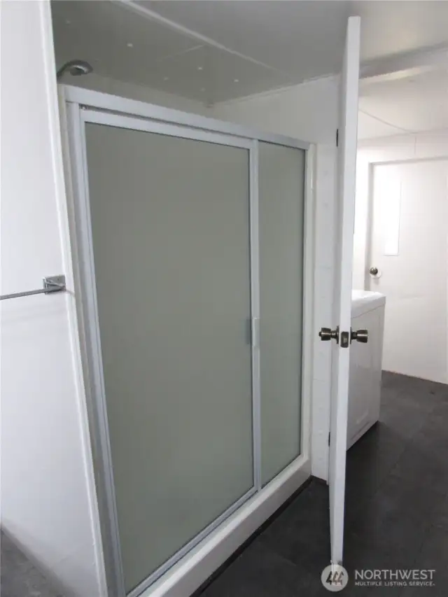 GLASS DOOR ENTRY TO SHOWER STALL.