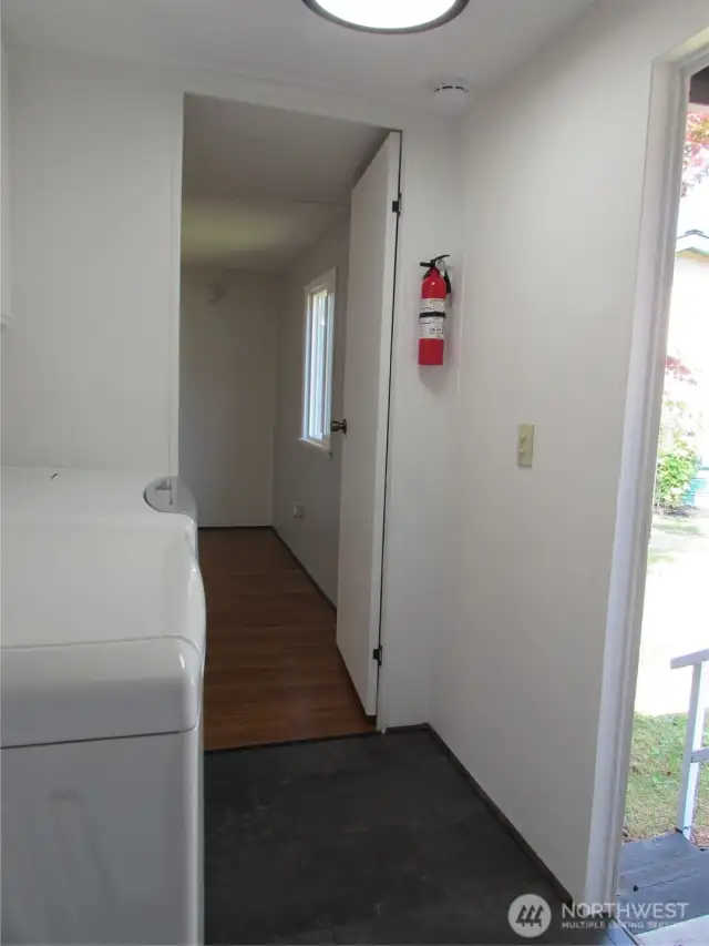 COVERED BACK DOOR PORCH TO RIGHT, PRIMARY BEDROOM ENTRY.