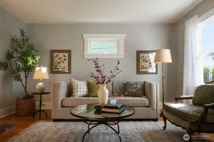 The living room is gracious and warm with hardwood floors and a brick fireplace. Open to the dining room and just a step from the kitchen.