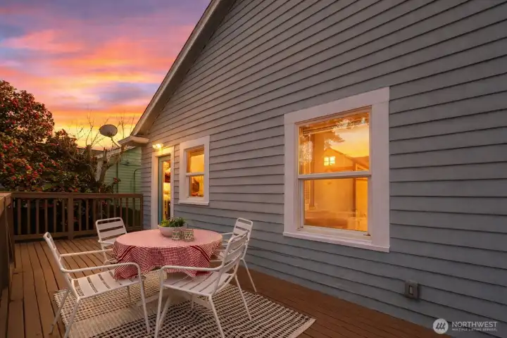 Large deck spans the width of the house with stairs down to the backyard.