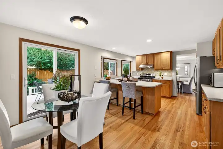 A great everyday dining setup with deck access just steps away and a clear sightline into the kitchen. The hardwood flooring ties the space together and supports a smooth flow for hosting.