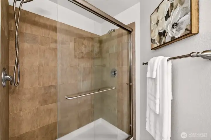 Tile surround shower with sliding glass doors for a clean, modern look and easy maintenance. A crisp, straightforward design that keeps the bath feeling open and practical.