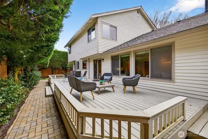 A generous entertaining deck that extends your living space outside, with multiple access points and plenty of room to configure distinct areas for dining and relaxing. The adjacent paver path adds a clean, finished look and easy circulation.