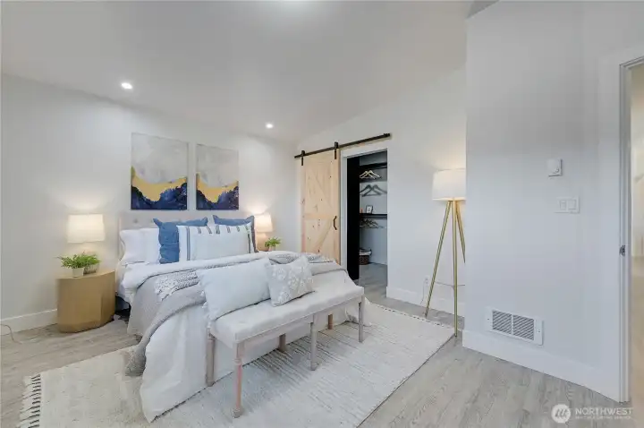 Primary bedroom showing barn door and walk-in closet