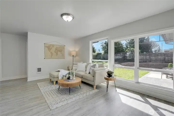 Family room with large windows overlooking backyard and patio area