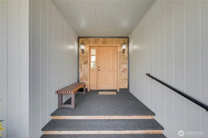 Covered front porch with sconce lighting and beautiful custom door (both sides open)