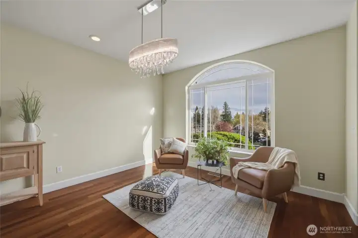 Formal Living Room with beautiful views and elegant light fixtures. Mahagony wood flooring throughout the main level of the home.