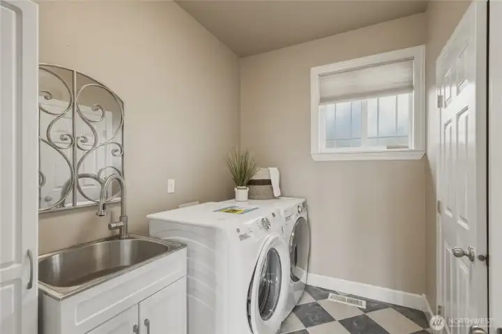 Spacious laundry room with storage, laundry sink and brand new washing machine. The half bathroom is located just behind this door in the laundry room.