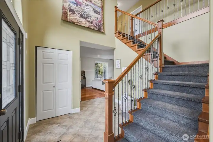 Large entry way with tiled floors and an elegant staircase leading to 4 bedrooms and 2 full bathrooms upstairs.