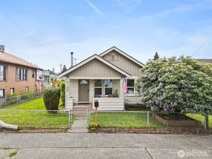 Charming Craftsman-style exterior features a welcoming covered front porch, mature landscaping, and classic curb appeal.