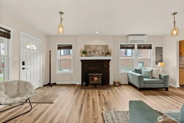 Cozy yet functional main living space highlighted by a charming brick fireplace, updated flooring, and stylish lighting throughout.