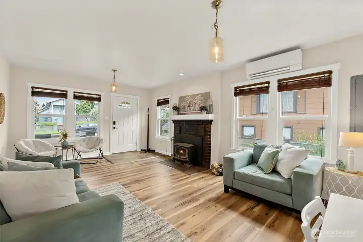 Sun-filled living room offers oversized windows, updated finishes, and a warm, inviting atmosphere throughout the home.
