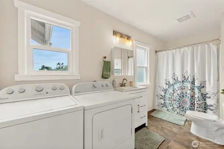 Large utility and bathroom space with updated vanity, full-size washer and dryer, and convenient everyday functionality.