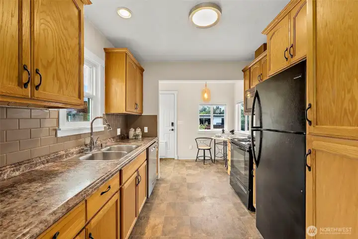 Functional kitchen features ample cabinetry, generous counter space, and a bright dining nook with backyard access.