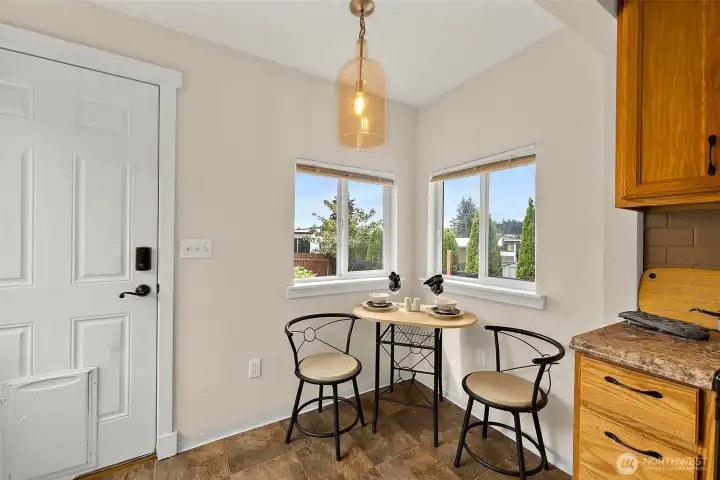 Charming dining nook surrounded by natural light creates the perfect spot for morning coffee or casual meals.